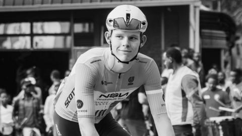 A black and white photograph of Finlay Tarling sitting on his bike