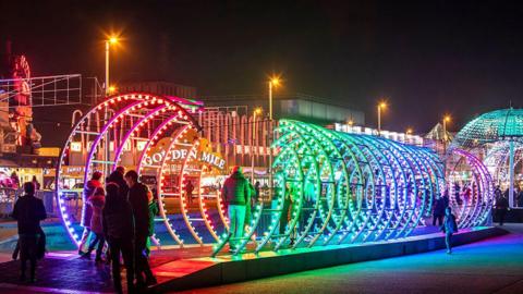 Visitors walk through the Spiro, a multi-coloured immersive sculptural tunnel of light on Blackpool Promenade.