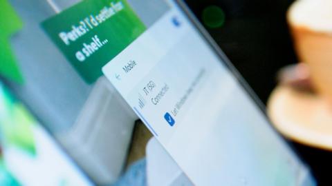A close up of a mobile phone. It is open in settings. JT(5G) can be seen to be connected.