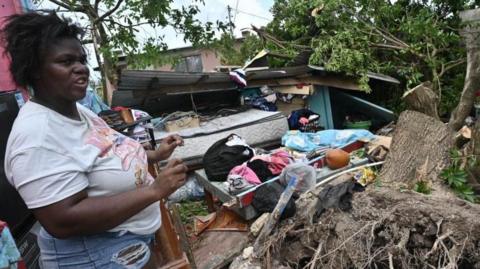 A woman looks at a house damaged by Hurricane Melissa in Saint Ann Parish in Middlesex County, Jamaica, 29 October 2025