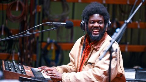 Michael Kiwanuka smiles as he plays a vintage keyboard during a session at the 鶹ҳ's Maida Vale studios in November 2024.