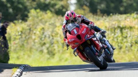 Davey Todd racing on a red bike with he number one on the front.