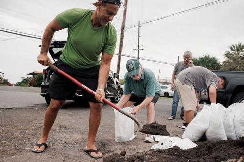 Captain Hook, Hawaii residents prepare stuff bags with sand in preparation of Tropical Storm Lala on Friday