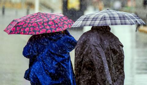 Two people walking with colourful umbrellas 