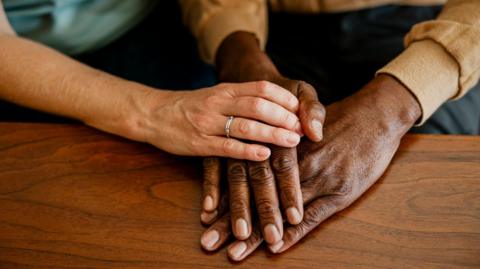 Close up of two adults' hands, one on top of the other