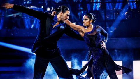 Balvinder Sopal and Julian Caillon wearing black outfits, and performing an Argentine Tango on the Strictly Come Dancing stage. Credit: BBC/Guy Levy.