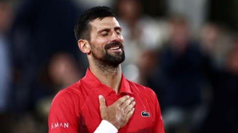 Novak Djokovic holds his heart after beating Alexander Zverev in the French Open quarter-finals