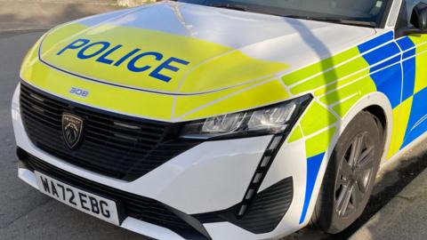 A Devon and Cornwall Police car parked on a road. 