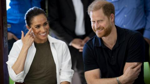 Prince Harry and Meghan sitting next to each other smiling in Jordan in February 2026