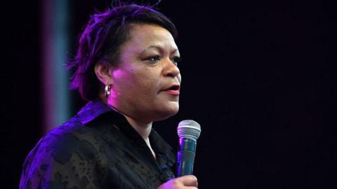Mayor LaToya Cantrell speaking at an event holding a microphone while speaking at an event 