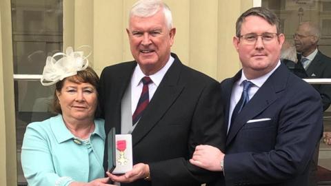 The Peterson family, Maggie, Alan and Hywel, outside Buckingham Palace after Alan received his OBE