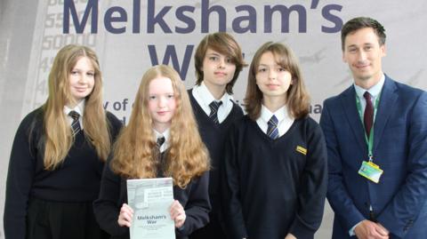 Students holding a copy of the book