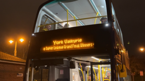 A double decker bus on a dark evening. At the front of the bus it reads: York Valkyrie Super League Grand Final Winners