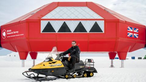 Dan McKenzie sits on a snowmobile outside the Halley VI Research Station in Antarctica
