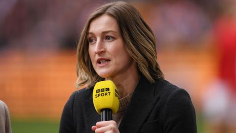 Ellen White, wearing a dark jacket and speaking into a yellow BBC Sport microphone