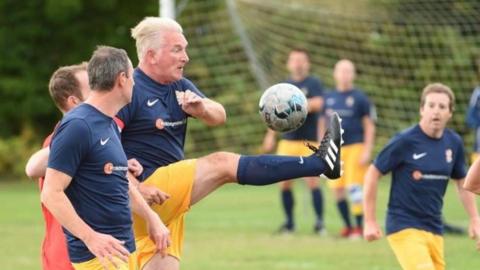 A player from Phoenix 681 FC kicking the ball during a football match