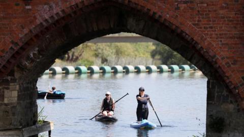 Paddle boarders on the River Great Ouse as temperatures climb over the bank holiday weekend during a heatwave, in Great Barford