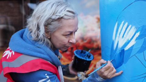 Artist Aimi Rix painting a pillar in Farley Hill, Luton