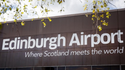 The side of a building at Edinburgh Airport carries the slogan 'where Scotland meets the world'.