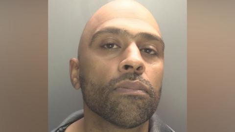Zaynul Shaffi pictured in a mugshot. He is bald and has a dark stubble beard.