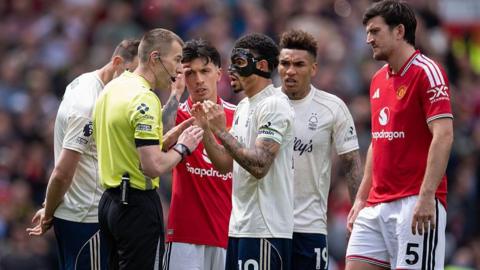 Nottingham Forest captain Morgan Gibbs-White talks with referee Michael Salisbury after he decides to allow a Manchester United goal despite VAR intervention