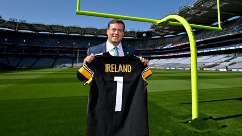 Pittsburgh Steelers executive Dan Rooney holding a Steelers jersey at Croke Park in 2023