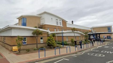 Street view image of Sunderland Royal Hospital, which is a sandy coloured building with a white roof.