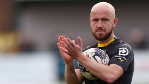 Paddy Madden applauds the fans after a game for Stockport County