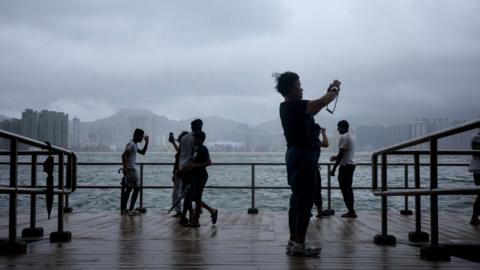 People watch waves along the seaside as super typhoon Ragasa moves away on September 24, 2025 in Hong Kong, China. 