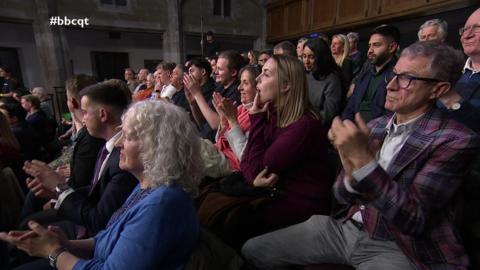 A tiered audience claps