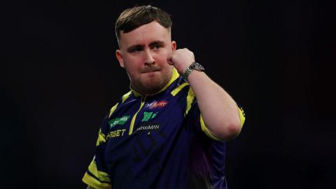 Luke Littler holds up his fist to celebrate
