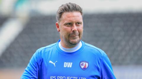 Danny Webb walking on the pitch wearing a Chesterfield shirt