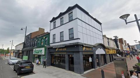 15 Waterloo Place. A Vietnamese pho restaurant is on the ground floor. The upper two storeys are white decorated with white cladding.