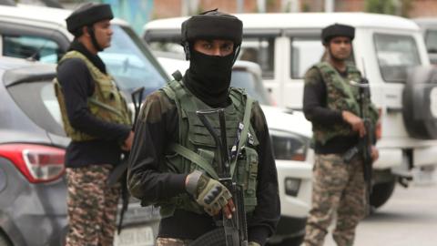 Three Indian paramilitary soldiers stand guard in Srinagar, in Indian-administered Kashmir on 12 May 2025 following a ceasefire agreement on 10 May, after days of military escalation.