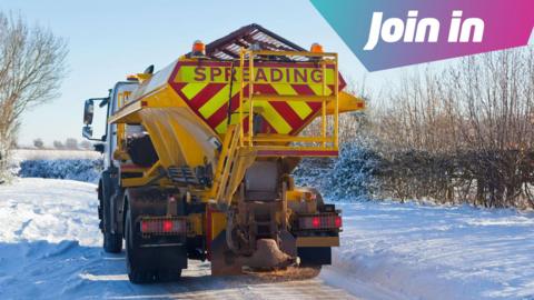A gritter truck on a snowy road, with text reading Join In on the top right corner of the image