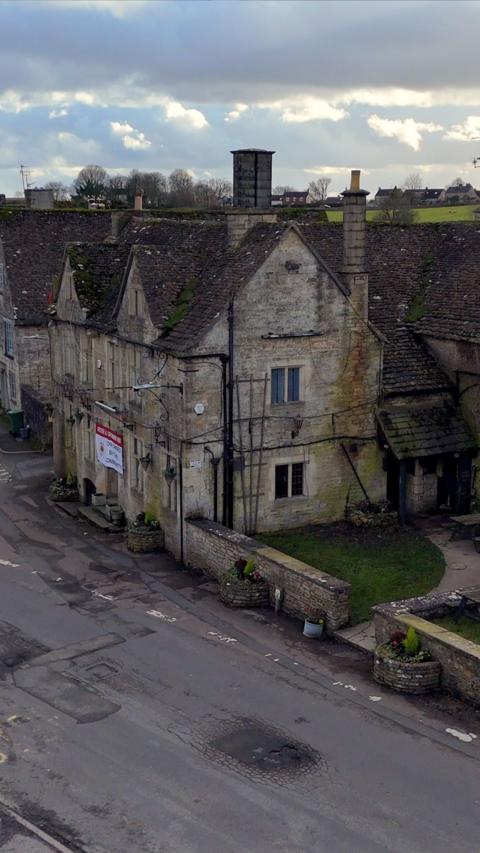 Aerial footage of pub with cloudy sky in the background
