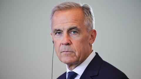 Canadian Prime Minister Mark Carney listens as German Chancellor Friedrich Merz speaks to the media following talks at the Chancellery on August 26, 2025 in Berlin, Germany. 