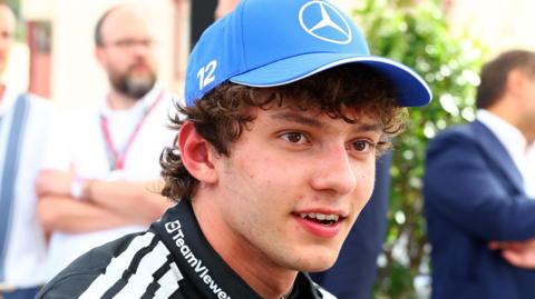 Kimi Antonelli, wearing a Mercedes cap, smiles after taking pole position for the Monaco Grand Prix