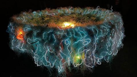 Angela Sandwith's Ghost Nest artwork at Durham Lumiere in 2023. It is a big nest-like structure lit up in blue, orange and green.