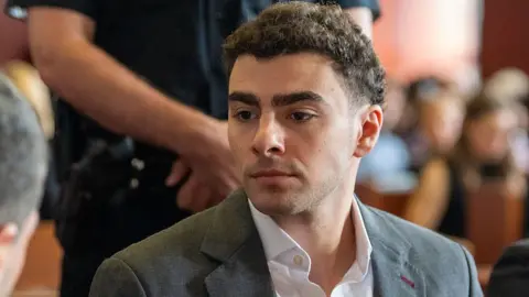 A close shot of Luigi Mangione as he sits in court