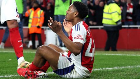 Myles Lewis-Skelly sitting down to celebrate a goal against Man City