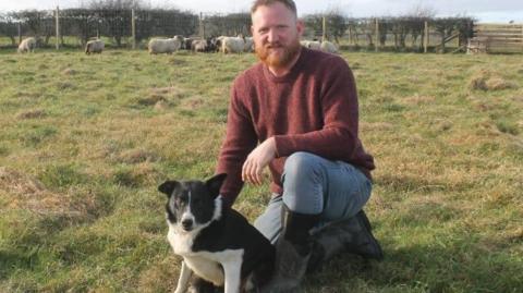 Dave Wilde kneeling with a dog