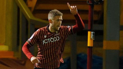 Will Swan celebrating his goal for Bradford with his arm raised