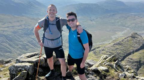 Michael Smith and Jack Stacey posing for a picture at the top of a mountain