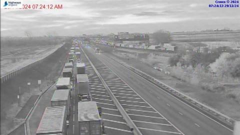 Black and white CCTV image of traffic building up on the M11 northbound (the left lane in the image).