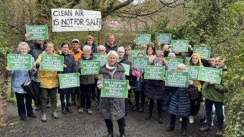 File photo: More than a dozen campaigners wave placards in English and Welsh, with one sign saying 'clean air is not for sale'