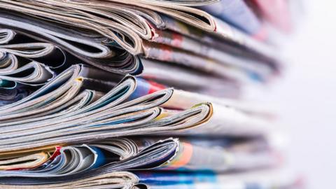 The spines of a pile of magazines on a blurred background 