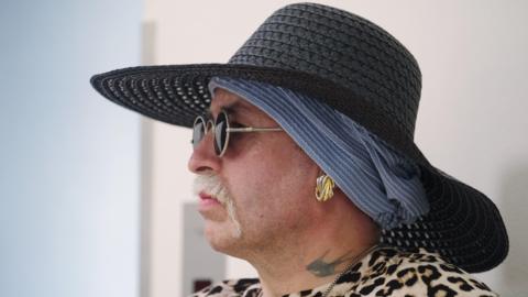 Marla-Svenja Liebich wears a blue hat and dark glasses - with a tattoo on her neck