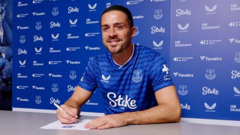 Jack Grealish in an Everton shirt signing his contract.