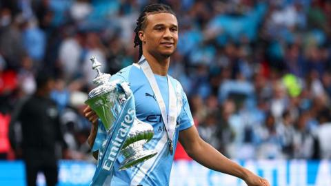 Nathan Ake holding the FA Cup as a Manchester City player